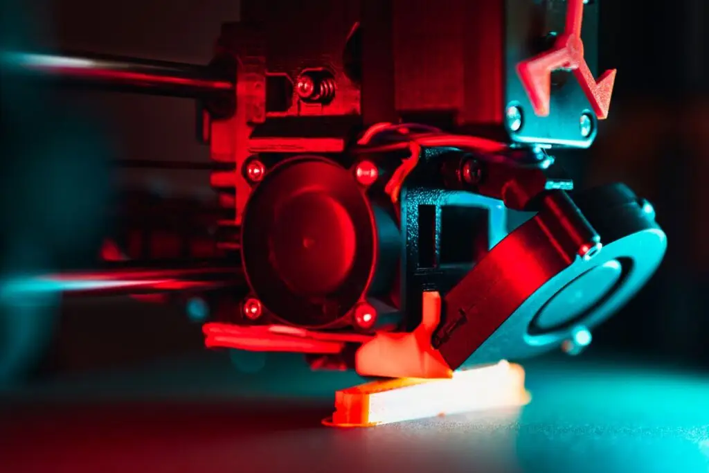 Close-up of a 3D printer nozzle laying the first layer of a print